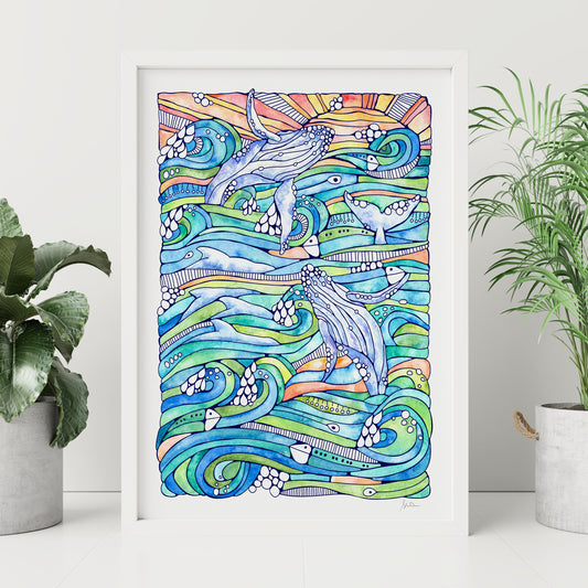 Colorful artwork of whales and waves in a frame on a white wall with plants.
