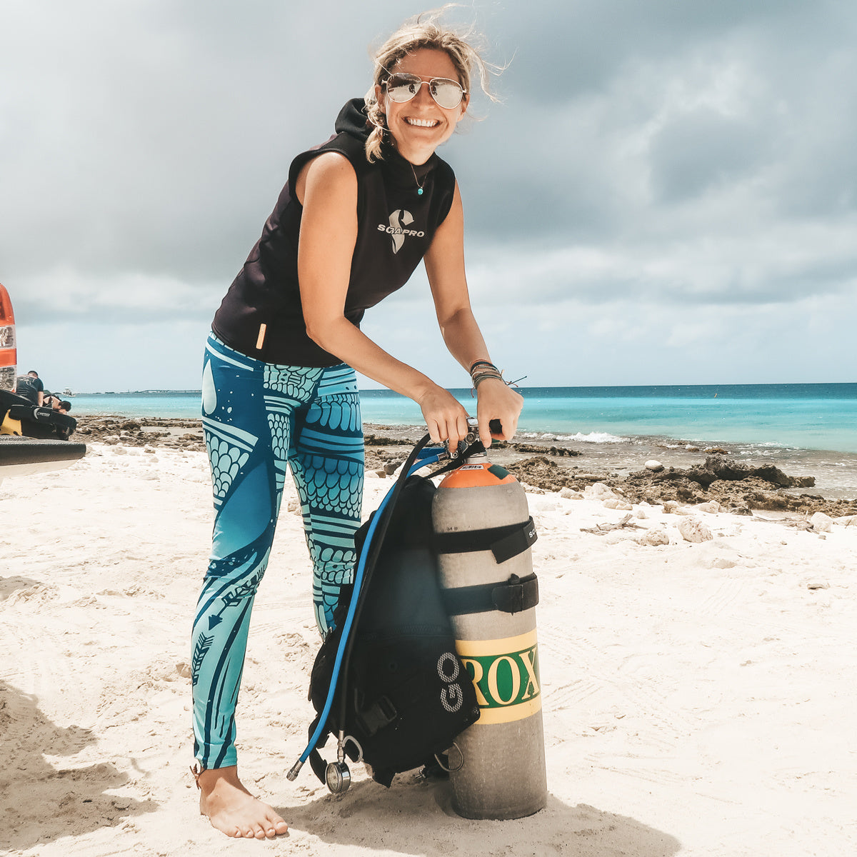 mermaid inspired ladies leggings with scales, arrows, and hearts in blues and greens